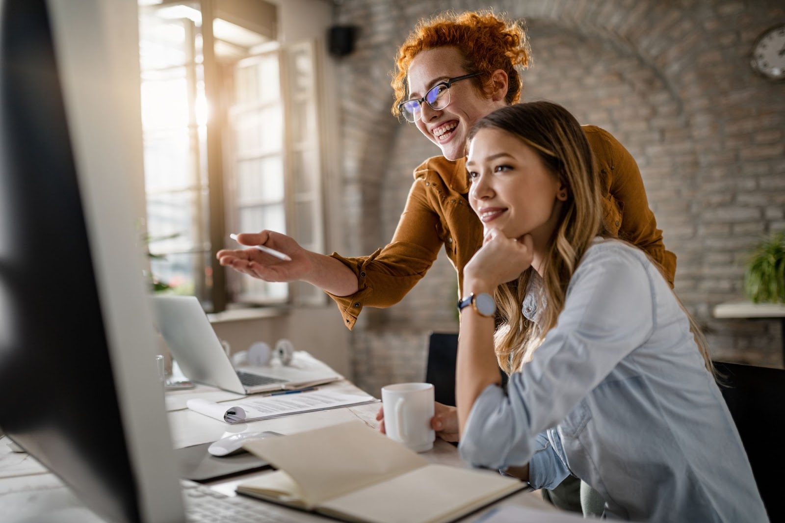 Two happy women discussing a project